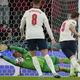 Harry Kane puts a PK rebound past keeper Kaspar Schmeichel, who apparently was heckled with a laser pointer by England fans..